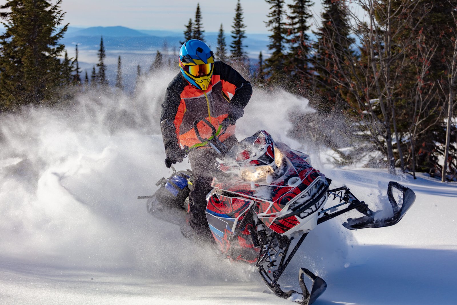 red and white Snowmobile Wraps riding in deep snow.