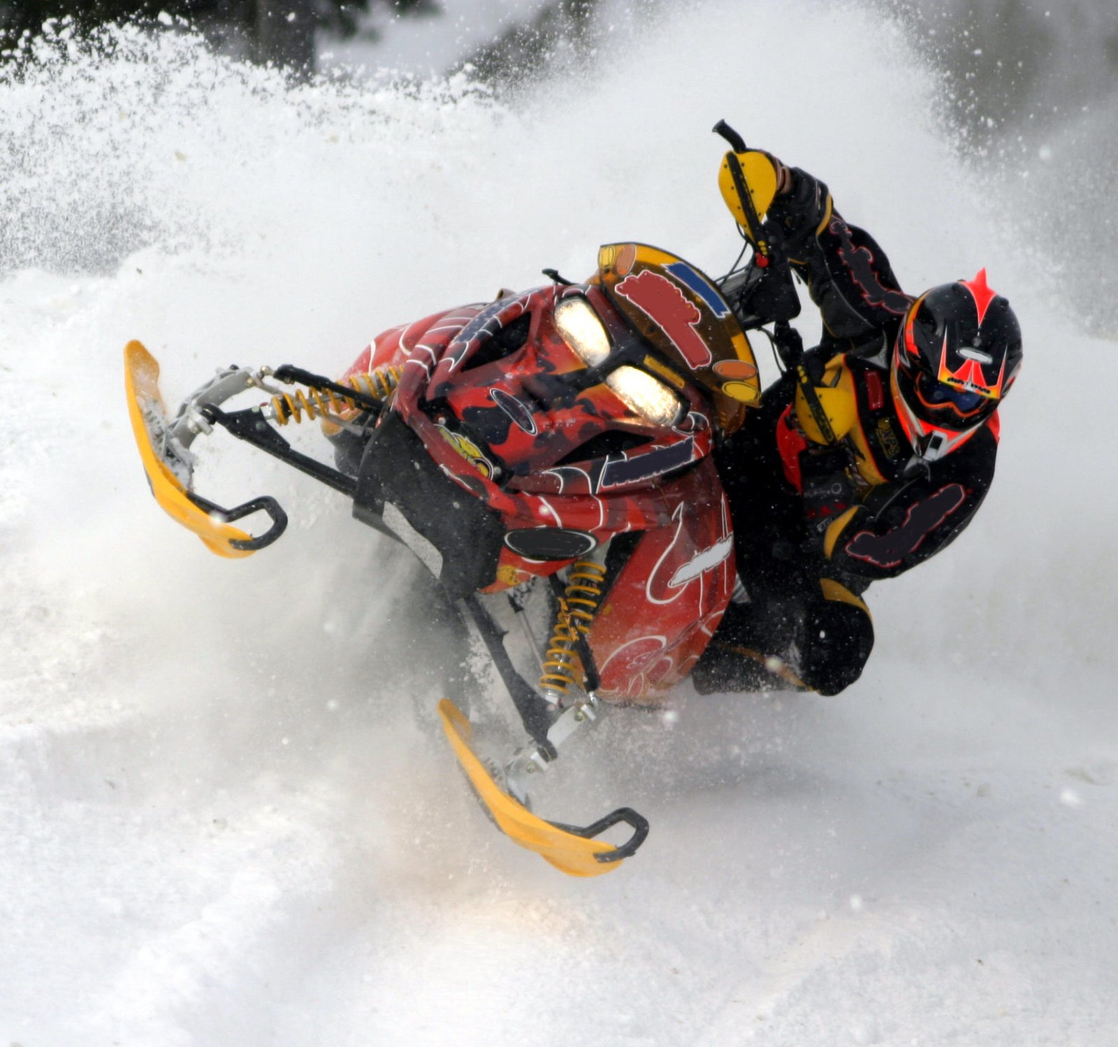 red and yellow Snowmobile Wraps riding in deep snow on one side.